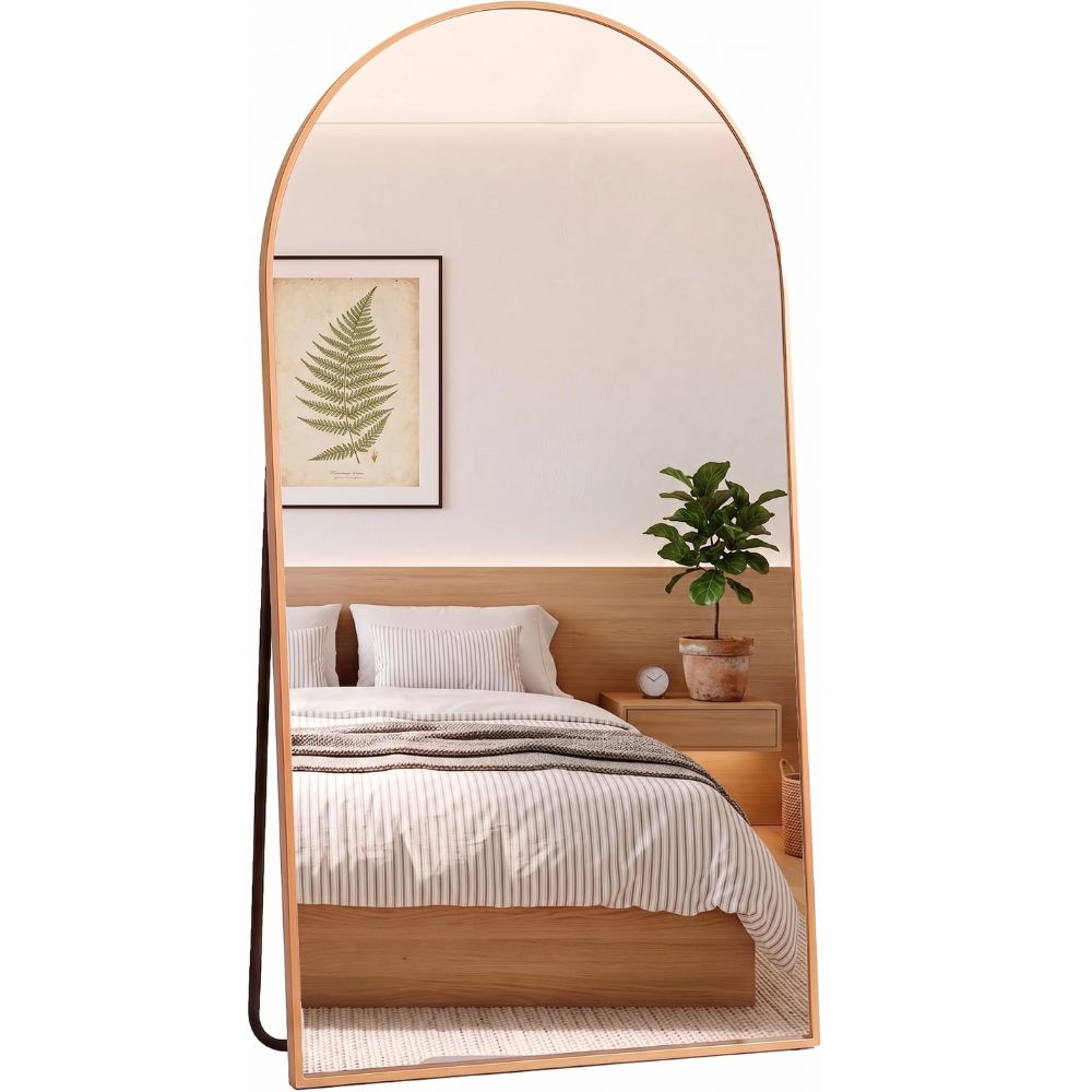 Espejo arqueado dorado de 161x52 cm decorando un dormitorio moderno.