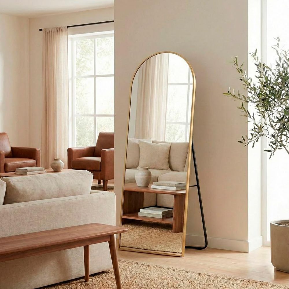 Espejo arqueado dorado de 161x52 cm decorando un dormitorio moderno.