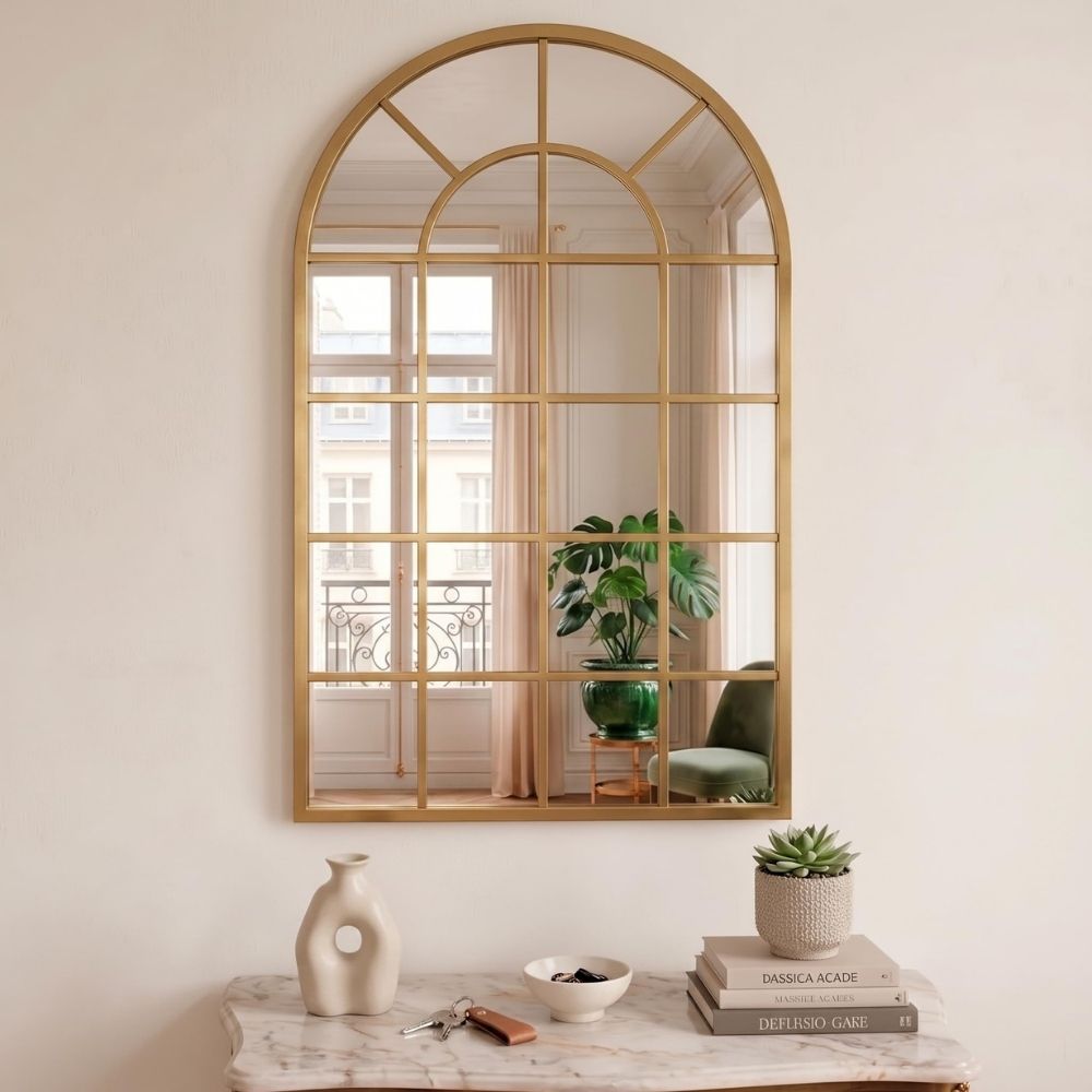 Espejo ventana en forma de arco Marctani con marco metálico dorado en salón moderno.