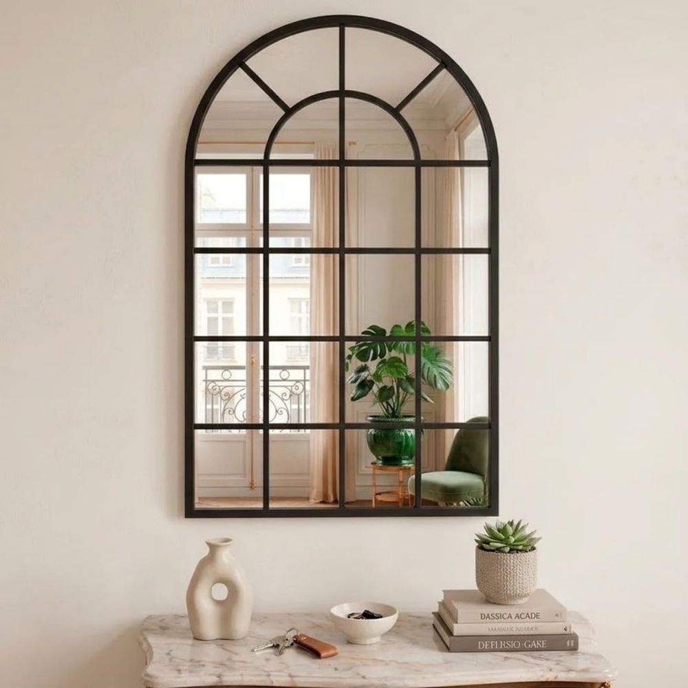 Espejo ventana en forma de arco Marctani con marco metálico negro en salón moderno.