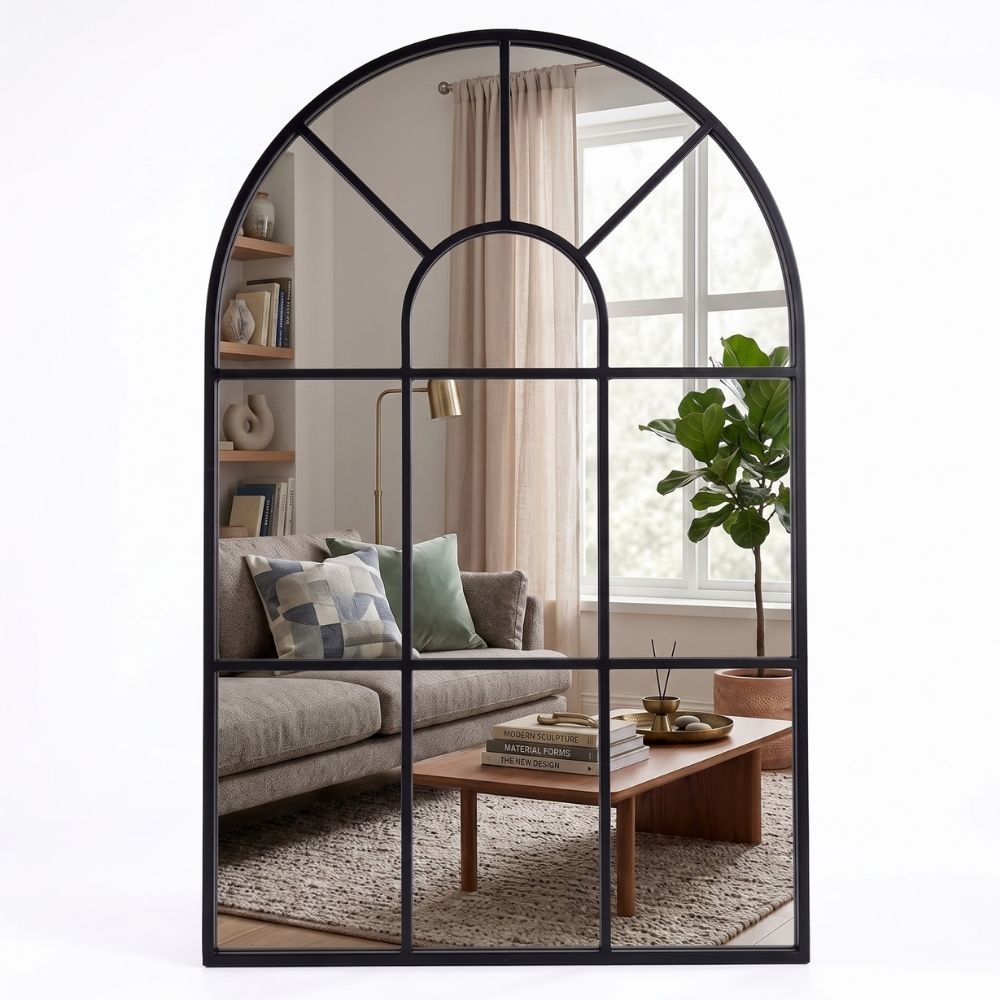 Espejo ventana en forma de arco Marctani con marco metálico negro en salón moderno.