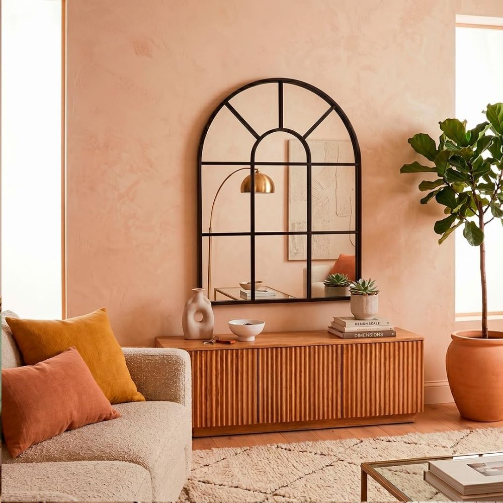 Espejo ventana en forma de arco Marctani con marco metálico negro en salón moderno.