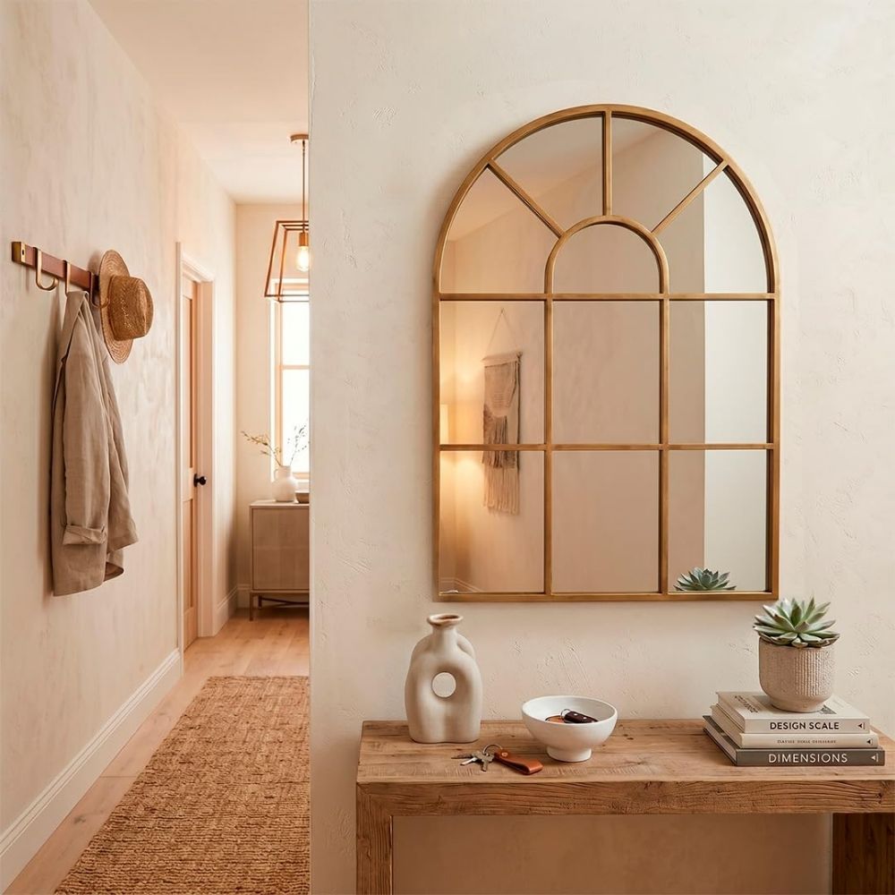 Espejo ventana en forma de arco Marctani con marco metálico dorado en salón moderno.